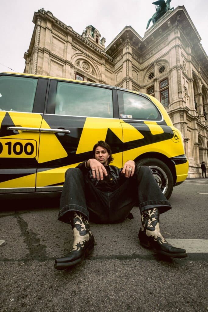 Mann lähnt sich an ein Taxi40100 Taxi