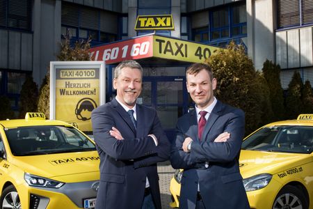 Geschäftsführer von Taxi40100 stehen vor dem Geschäftgebäude