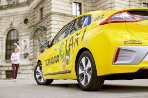 Elektronisches E-Taxi von Taxi40100 holt einen Besucher ab