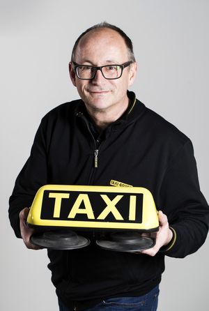 Mitarbeiter hält eine Taxileuchte