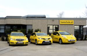 Eine Reihe an verschiedenen Taxis vor der taxischule.at